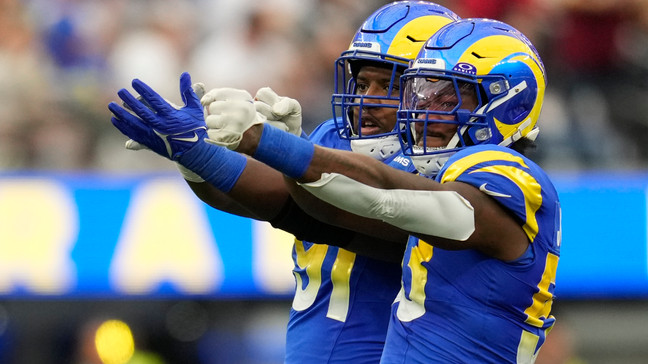 Los Angeles Rams defensive tackle Kobie Turner (91) and linebacker Ernest Jones (53) celebrate after a sack during the first half of an NFL football game against the Washington Commanders Sunday, Dec. 17, 2023, in Inglewood, Calif. (AP Photo/Marcio Jose Sanchez)