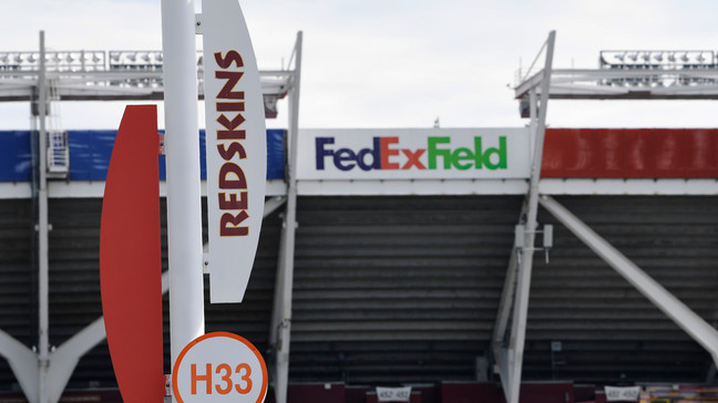 FILE - Signs for the Washington Redskins are displayed outside FedEx Field in Landover, Md., Monday, July 13, 2020. It was noticeable when new Washington Commanders owners Josh Harris and Magic Johnson referred to the old Redskins name in their opening news conference. Webster's New World College Dictionary's entry for redskin says it is ânow considered by many to be an offensive term.â (AP Photo/Susan Walsh, File)